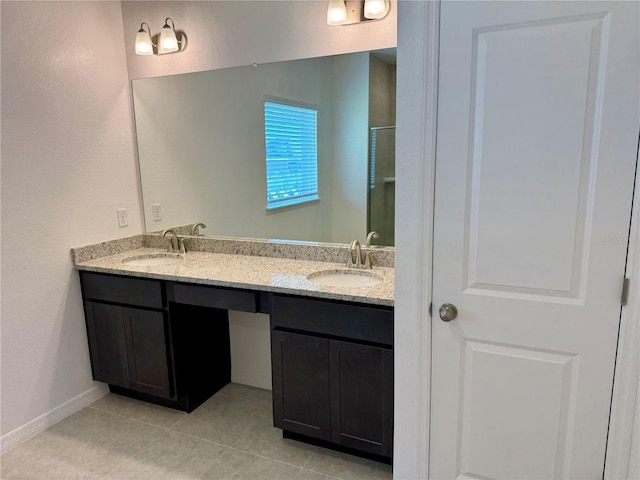 27206 Adams St, Punta Gorda, FL 33983 - full bath featuring tile patterned flooring, double vanity, a shower with door, a textured wall, and baseboards
