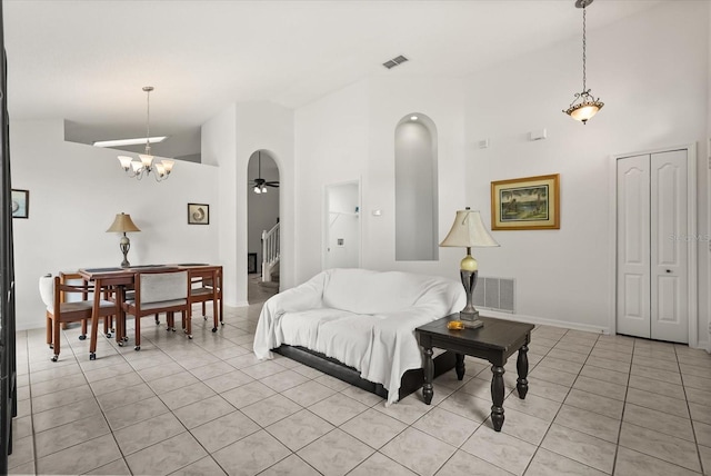 4249 Andover Cay Blvd, Orlando, FL 32825 - living room featuring high vaulted ceiling, light tile patterned floors, stairs, arched walkways, and a chandelier