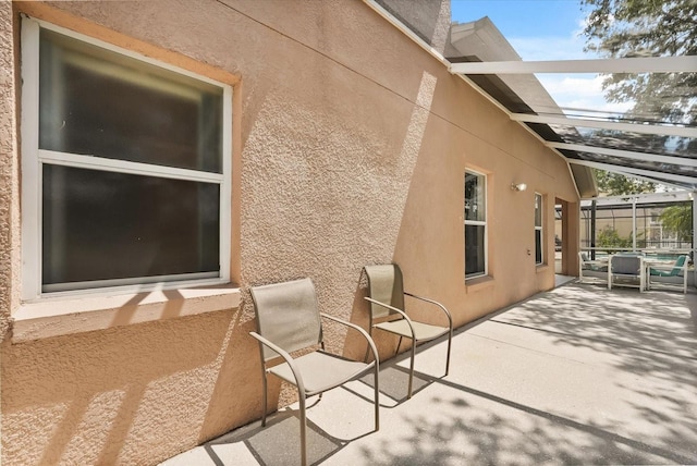 4249 Andover Cay Blvd, Orlando, FL 32825 - view of side of property featuring stucco siding, a patio area, and glass enclosure