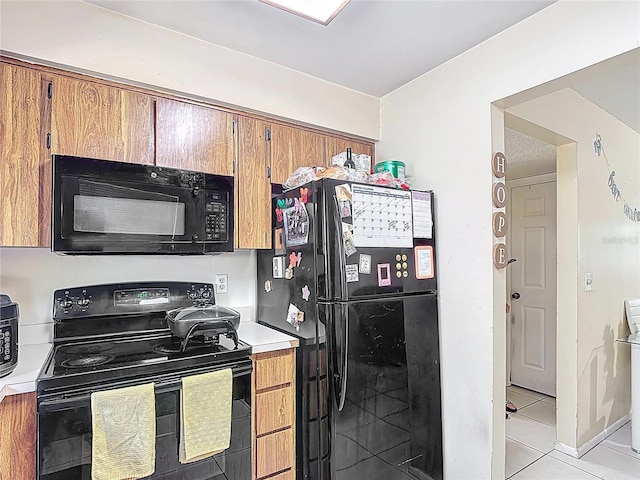 1748 Foxhall Cir Unit 1748, Kissimmee, FL 34741 - kitchen with black appliances, light countertops, light tile patterned flooring, and brown cabinetry