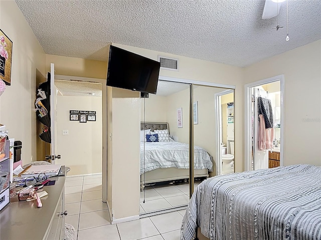 1748 Foxhall Cir Unit 1748, Kissimmee, FL 34741 - bedroom featuring a textured ceiling, light tile patterned floors, a closet, and ensuite bath