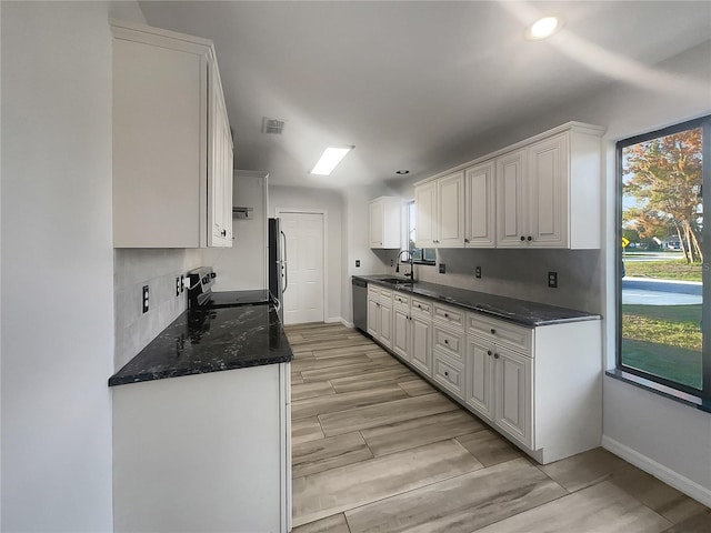 3321 Crimson Ln, Deltona, FL 32738 - kitchen featuring stainless steel appliances, baseboards, a sink, white cabinets, and light wood-style flooring