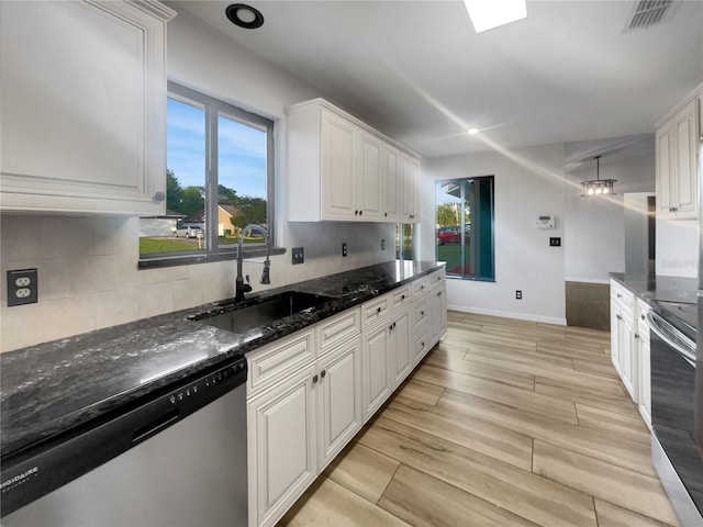 3321 Crimson Ln, Deltona, FL 32738 - kitchen with appliances with stainless steel finishes, a sink, backsplash, white cabinets, and dark stone countertops