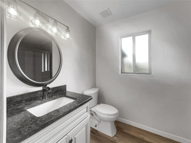 3321 Crimson Ln, Deltona, FL 32738 - half bathroom featuring wood finished floors, toilet, vanity, and baseboards