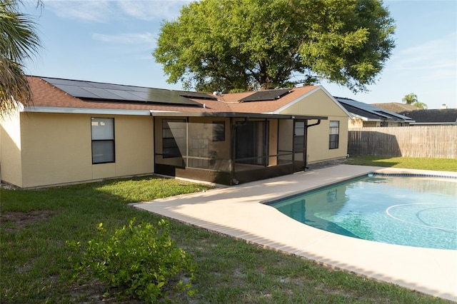 5547 Garden Grove Cir, Winter Park, FL 32792 - back of house featuring a sunroom, roof mounted solar panels, stucco siding, and roof with shingles