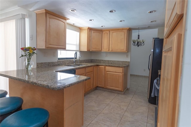 5547 Garden Grove Cir, Winter Park, FL 32792 - kitchen featuring a sink, light brown cabinets, a peninsula, a kitchen breakfast bar, and freestanding refrigerator