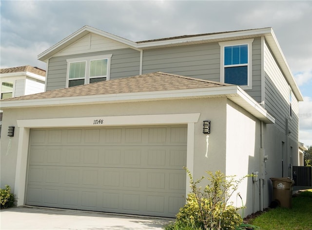 17148 Cagan Crossings Blvd, Clermont, FL 34714 - view of front of home with a shingled roof, concrete driveway, central AC, and stucco siding
