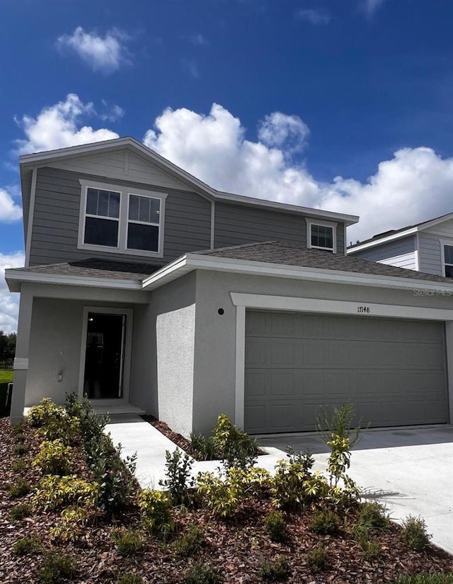 17148 Cagan Crossings Blvd, Clermont, FL 34714 - view of front facade with a shingled roof, driveway, an attached garage, and stucco siding