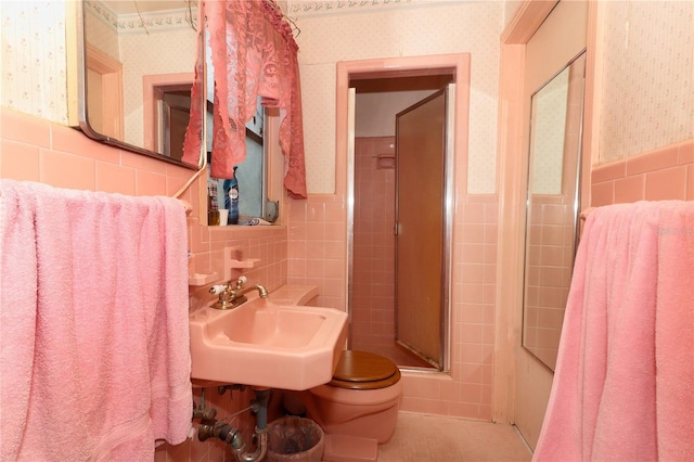330 Phoenix Ave, Daytona Beach, FL 32118 - full bathroom featuring tile walls, wallpapered walls, a sink, a stall shower, and toilet
