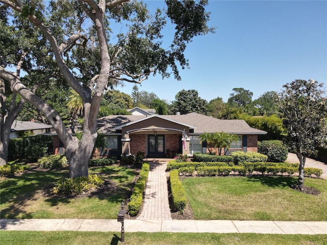5127 Leeward Way, Orlando, FL 32809 - view of front of home featuring french doors, a front lawn, and brick siding
