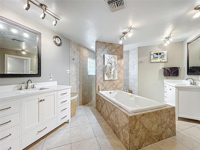 5127 Leeward Way, Orlando, FL 32809 - bathroom with tile patterned floors, rail lighting, a bath, and a textured ceiling