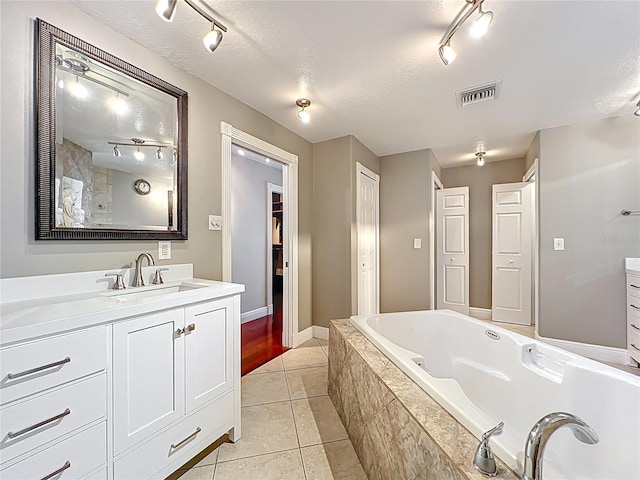5127 Leeward Way, Orlando, FL 32809 - full bath with a garden tub, track lighting, vanity, tile patterned flooring, and a textured ceiling