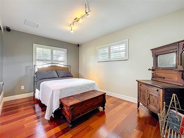 5127 Leeward Way, Orlando, FL 32809 - bedroom with multiple windows, hardwood / wood-style floors, baseboards, and rail lighting