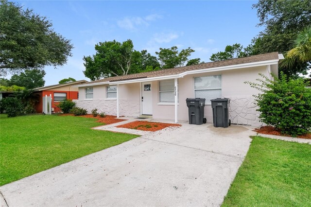 6426 Eden Ln, Tampa, FL 33634 - single story home with a front lawn, stone siding, stucco siding, and driveway