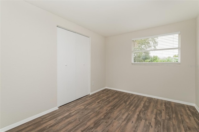 6426 Eden Ln, Tampa, FL 33634 - unfurnished bedroom with dark wood-type flooring, a closet, and baseboards