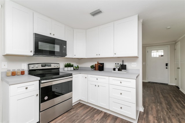 6426 Eden Ln, Tampa, FL 33634 - kitchen featuring electric stove, black microwave, dark wood-style flooring, and light countertops