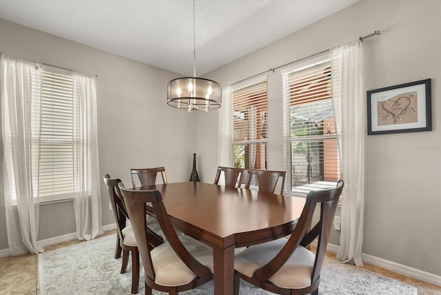 dining space featuring a chandelier and baseboards
