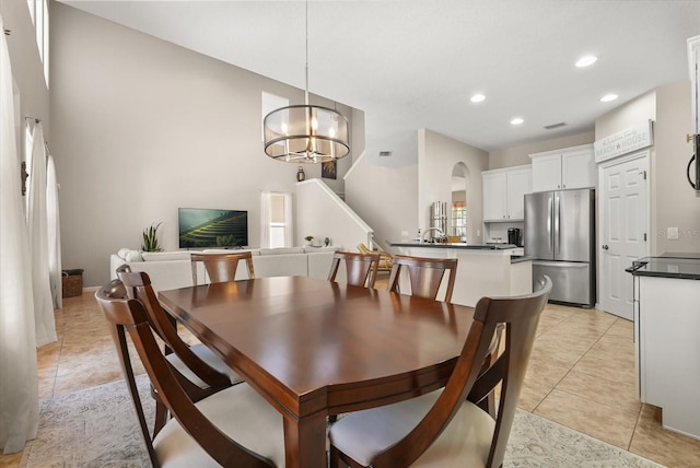 dining area featuring light tile patterned floors, recessed lighting, a chandelier, arched walkways, and stairs