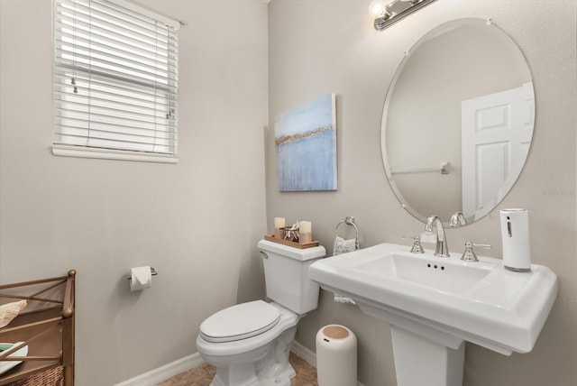 bathroom with toilet, baseboards, a sink, and tile patterned flooring