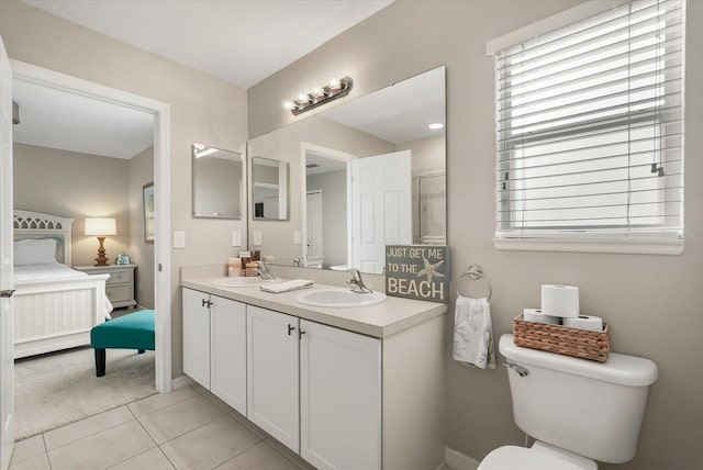 ensuite bathroom with toilet, tile patterned flooring, baseboards, and double vanity