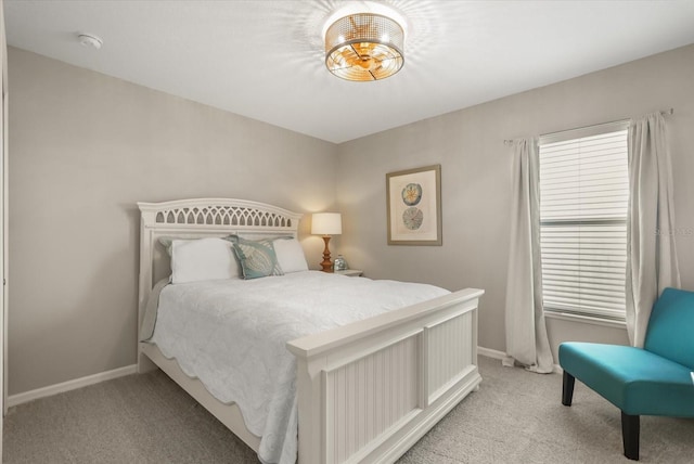 bedroom with light colored carpet and baseboards