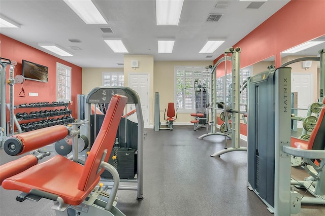 exercise room with healthy amount of natural light and baseboards