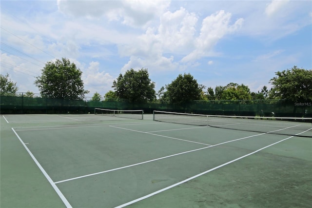 view of tennis court featuring fence and community basketball court