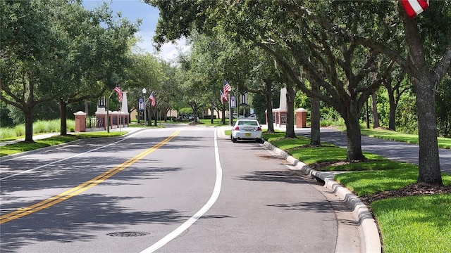 view of asphalt road featuring curbs