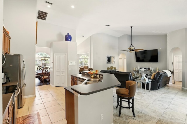 3451 Players Point Loop, Apopka, FL 32712 - kitchen featuring arched walkways, a sink, high vaulted ceiling, dark countertops, and stainless steel appliances