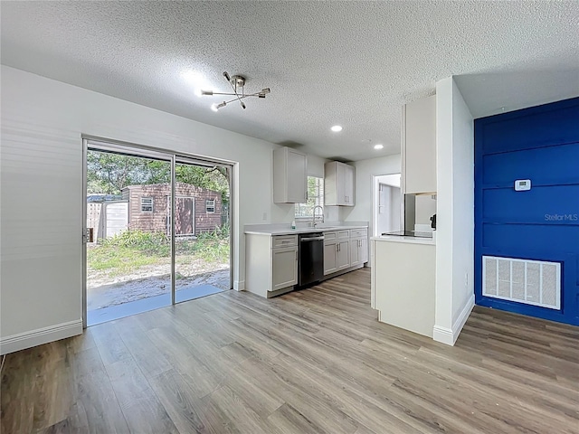 1307 Jean Ct, Eustis, FL 32726 - kitchen featuring dishwashing machine, a textured ceiling, light countertops, light wood-type flooring, and baseboards