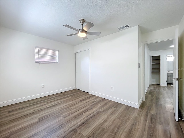 1307 Jean Ct, Eustis, FL 32726 - unfurnished bedroom featuring wood finished floors, a closet, baseboards, a textured ceiling, and a ceiling fan