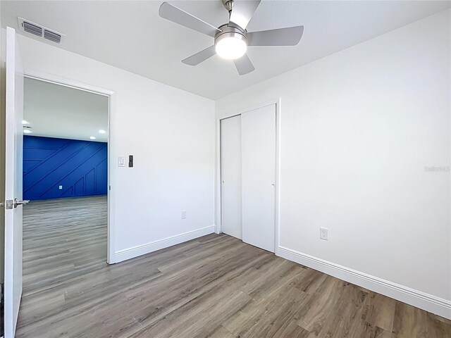 1307 Jean Ct, Eustis, FL 32726 - unfurnished bedroom with wood finished floors, baseboards, a closet, and ceiling fan