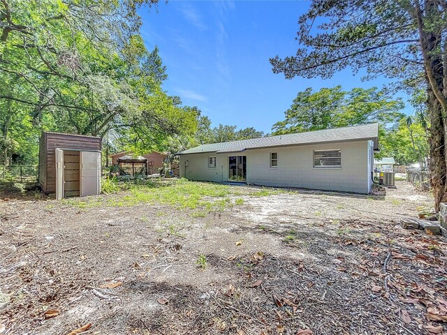 1307 Jean Ct, Eustis, FL 32726 - rear view of house featuring a storage shed, fence, an outbuilding, and concrete block siding