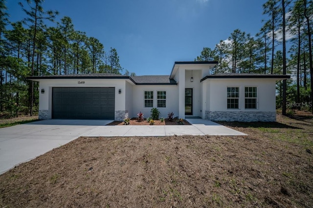 13419 SW 77th Ave, Ocala, FL 34473 - view of front facade with stone siding, stucco siding, an attached garage, and concrete driveway
