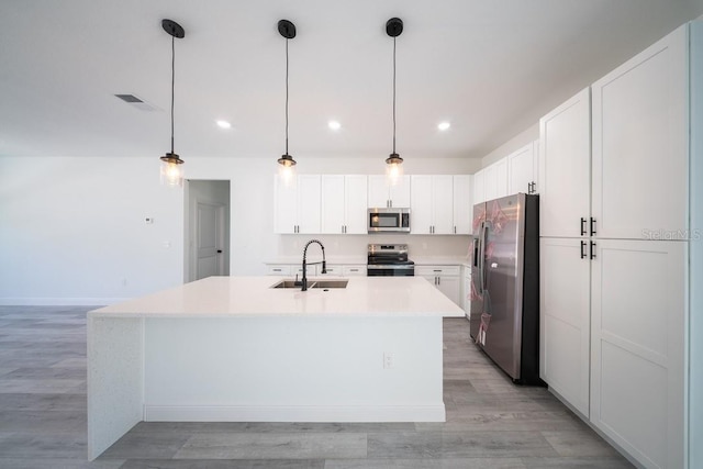 13419 SW 77th Ave, Ocala, FL 34473 - kitchen featuring appliances with stainless steel finishes, a sink, light countertops, light wood-style floors, and white cabinets