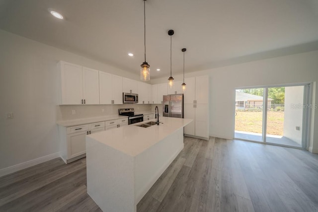 13419 SW 77th Ave, Ocala, FL 34473 - kitchen featuring appliances with stainless steel finishes, light wood finished floors, a center island with sink, a sink, and recessed lighting