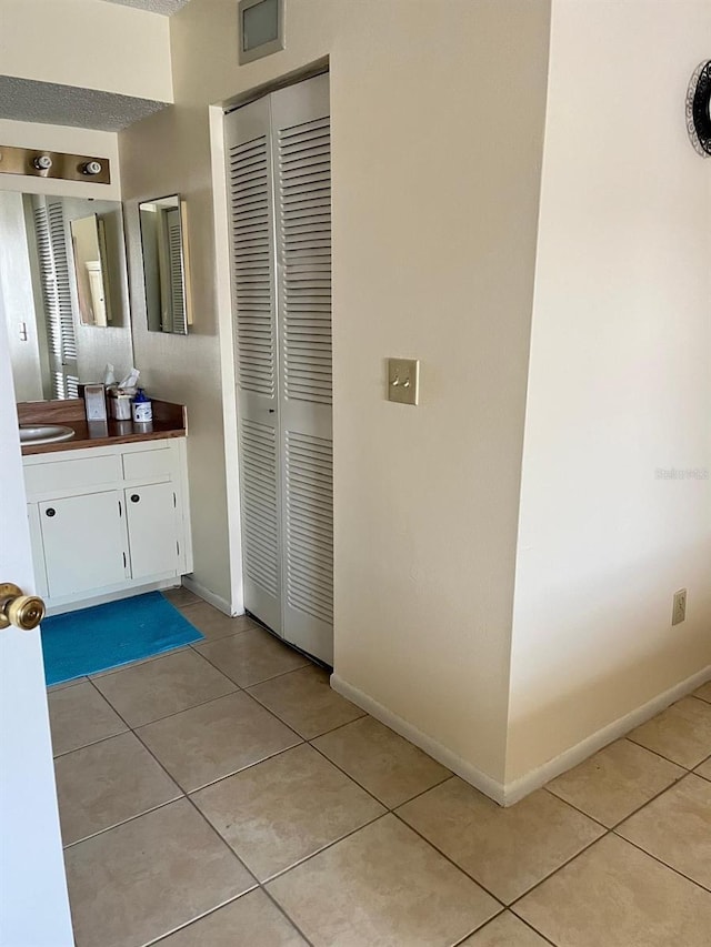 bathroom with tile patterned floors, baseboards, and vanity