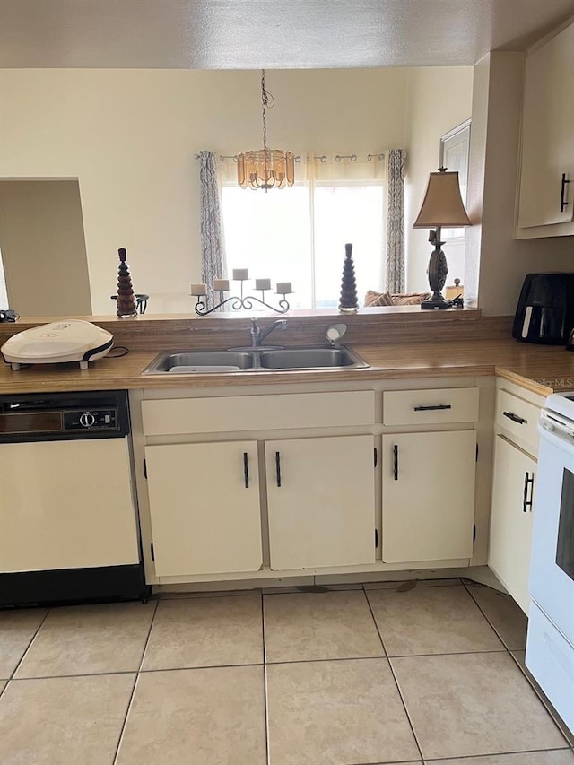 kitchen featuring dishwasher, a sink, white electric range, light tile patterned floors, and white cabinetry