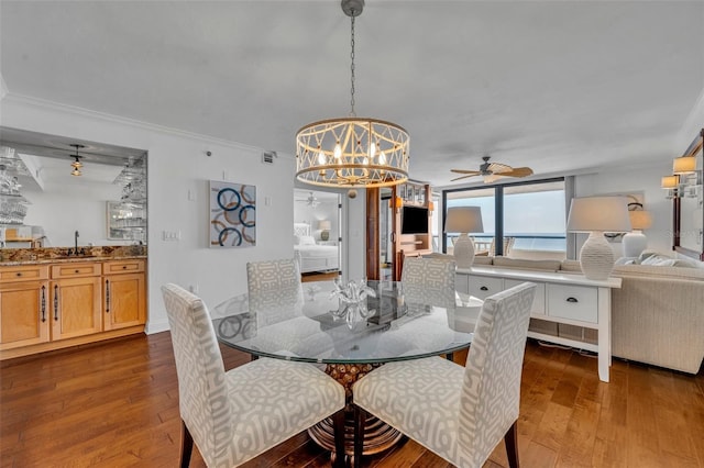 5275 S Atlantic Ave Unit 506, New Smyrna Beach, FL 32169 - dining room featuring a chandelier, hardwood / wood-style floors, a ceiling fan, and crown molding