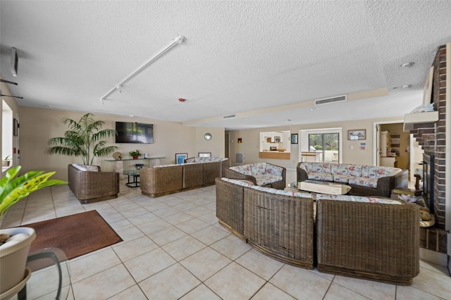 5275 S Atlantic Ave Unit 506, New Smyrna Beach, FL 32169 - living area with light tile patterned flooring, a textured ceiling, track lighting, and a brick fireplace