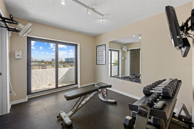 5275 S Atlantic Ave Unit 506, New Smyrna Beach, FL 32169 - exercise room featuring baseboards, track lighting, and a textured ceiling