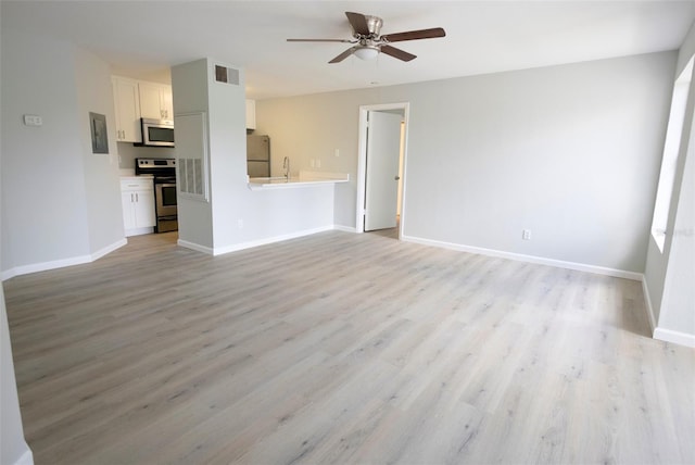 4704 Walden Cir Unit 21, Orlando, FL 32811 - unfurnished living room with ceiling fan, light wood finished floors, a sink, and baseboards