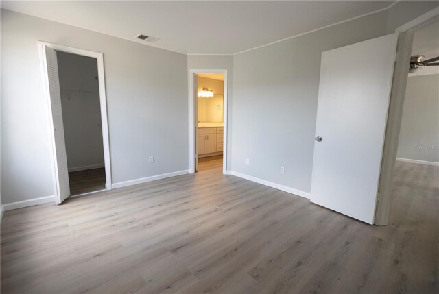 4704 Walden Cir Unit 21, Orlando, FL 32811 - unfurnished bedroom with wood finished floors, a spacious closet, baseboards, and a closet