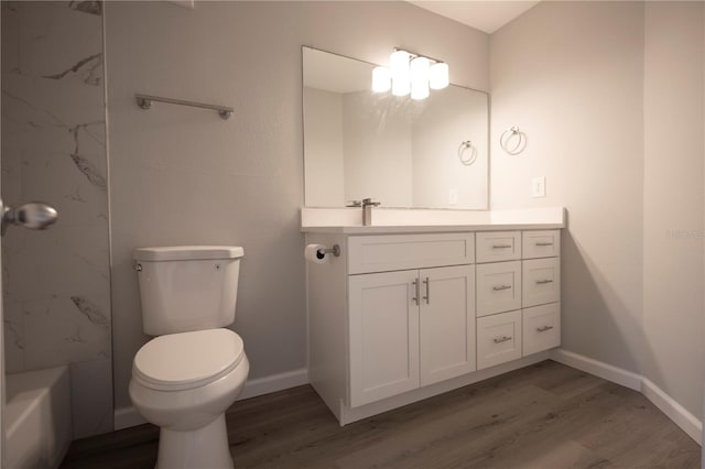 4704 Walden Cir Unit 21, Orlando, FL 32811 - bathroom with wood finished floors, toilet, vanity, and baseboards