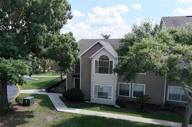 4704 Walden Cir Unit 21, Orlando, FL 32811 - view of property exterior featuring stairway, a lawn, and roof with shingles
