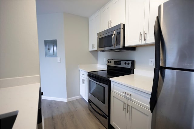 4704 Walden Cir Unit 21, Orlando, FL 32811 - kitchen with stainless steel appliances, light wood-style flooring, electric panel, light countertops, and white cabinetry