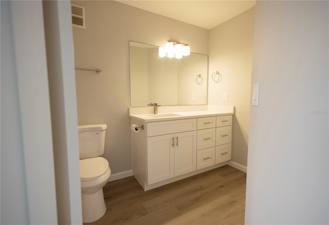 4704 Walden Cir Unit 21, Orlando, FL 32811 - half bath with wood finished floors, toilet, vanity, and baseboards