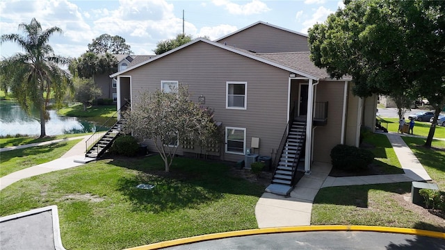 4704 Walden Cir Unit 21, Orlando, FL 32811 - view of home's exterior featuring stairway, a yard, cooling unit, and a water view