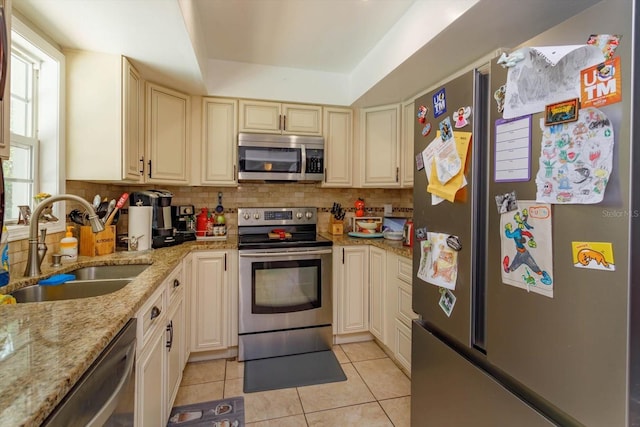 11435 Aries Dr, Orlando, FL 32837 - kitchen featuring stainless steel appliances, a sink, light tile patterned flooring, decorative backsplash, and cream cabinets