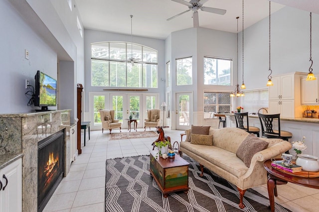 334 N Shadowbay Blvd, Longwood, FL 32779 - living area with a towering ceiling, light tile patterned floors, a ceiling fan, a premium fireplace, and a chandelier